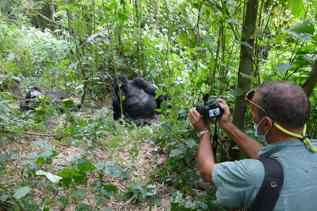Tourist taking a photo on a memorable gorilla tracking in Mgahinga trip